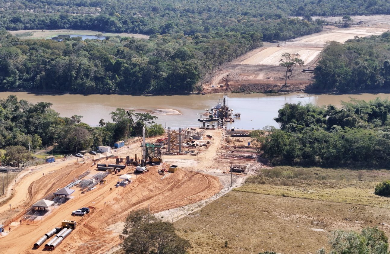 Vista aérea de obra de fundação em andamento sobre um curso d'água, no trecho da Ferrovia de Mato Grosso